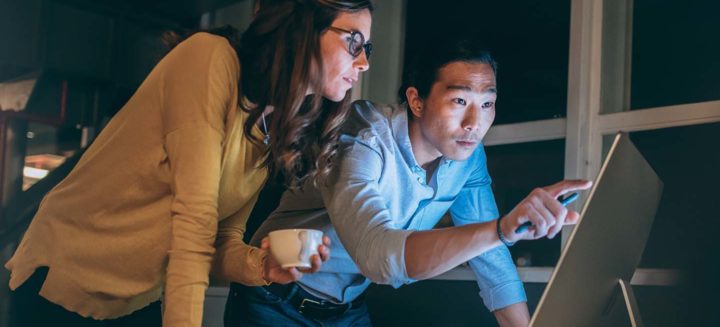 Two business people looking at computer screen